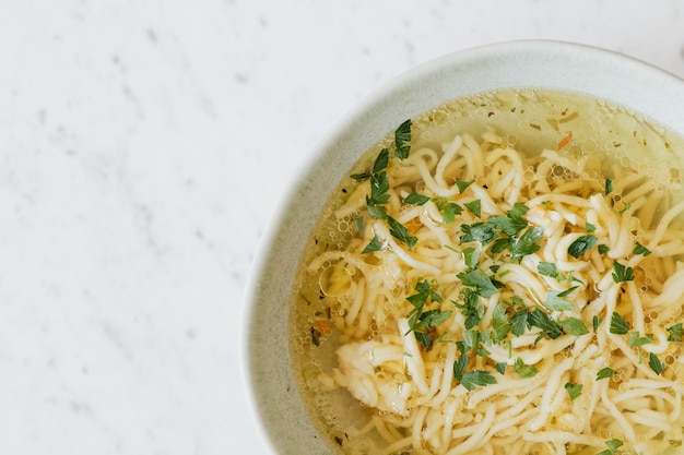 Foto brodo - zuppa di pollo con tagliatelle in una ciotola.