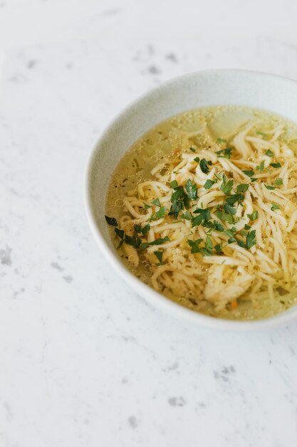 Foto brodo - zuppa di pollo con tagliatelle in una ciotola.