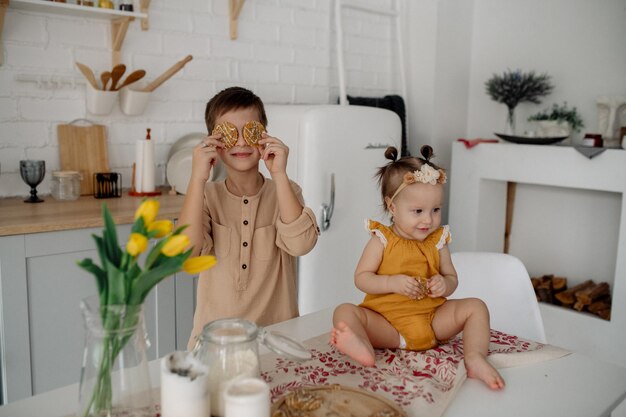 Brother and little sister are hugging in the kitchen Family life at home