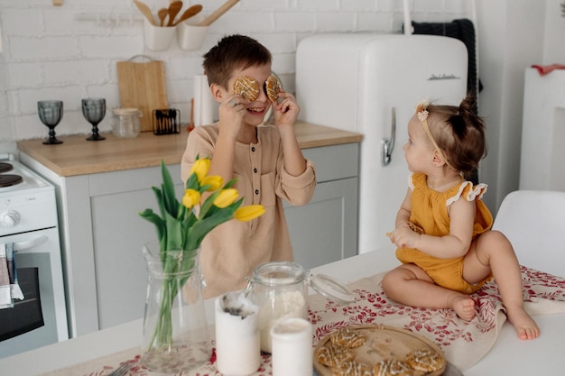 Brother and little sister are hugging in the kitchen Family life at home