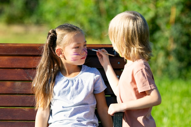 Brother paints on sister's face