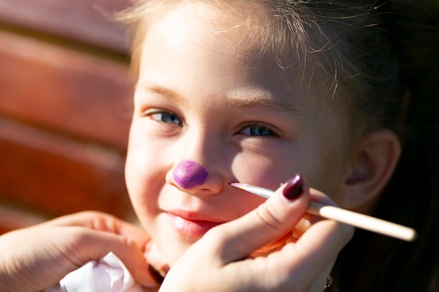 Brother paints on sister's face