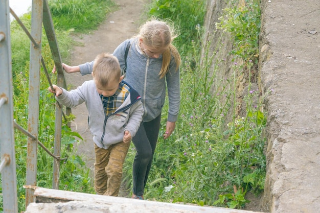 Brother and sister are walking the stairs A teenage girl and a little boy