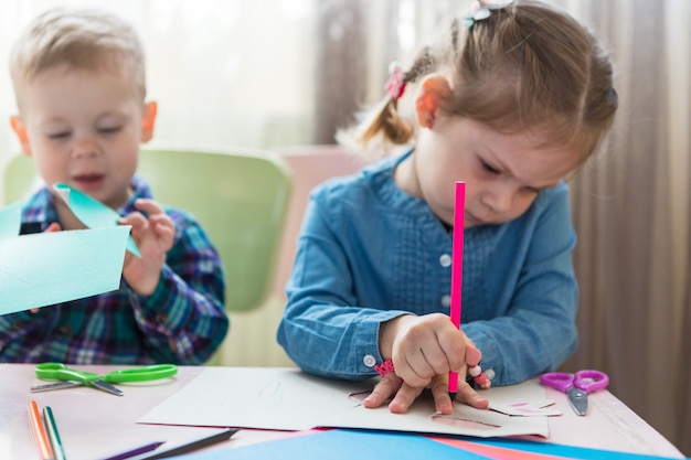 Brother and sister drawing at a table