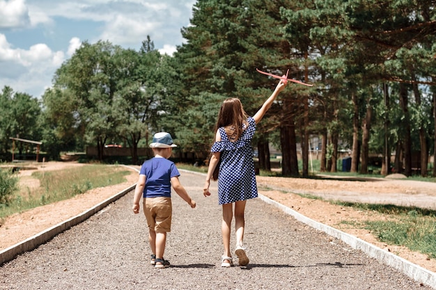 Brother and sister go ahead on the road and launch the airplane\
begin to travel from childhood even in the imagination the view\
from the back