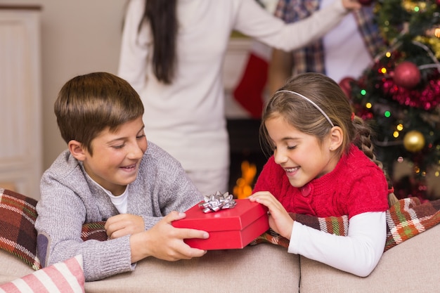 Photo brother and sister holding a gift