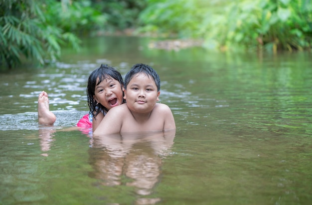 brother and sister play water in river