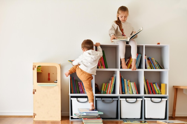 Foto fratello e sorella che leggono libri nella stanza dei bambini