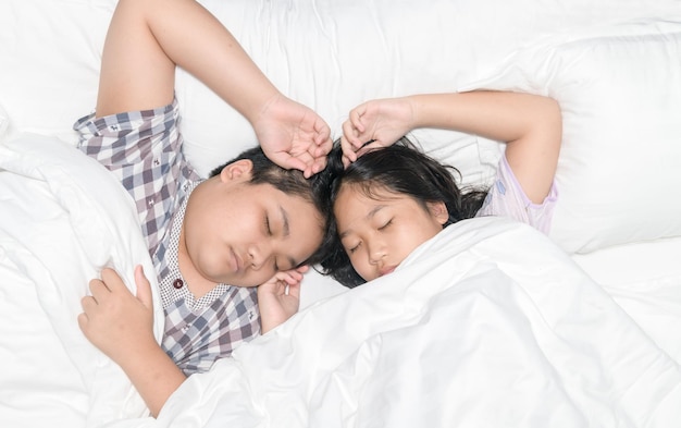 Brother and sister sleep together with blanket, rest and healthy concept