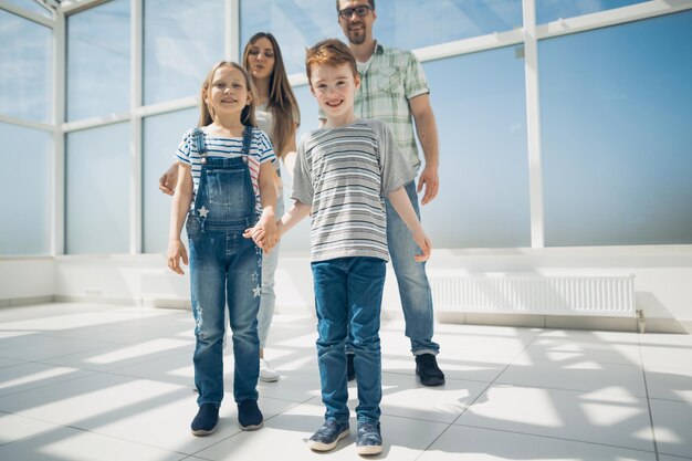 Brother and sister with their parents standing in a spacious apartment