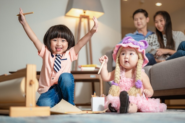 兄は妹と遊んでいた彼は手を上げて敷物の上で妹を笑った