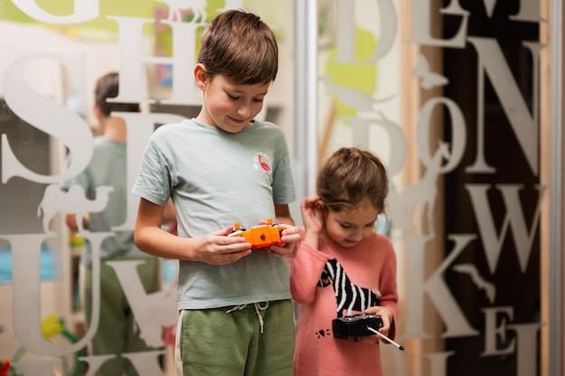 Brother with sister play remote control in children's room