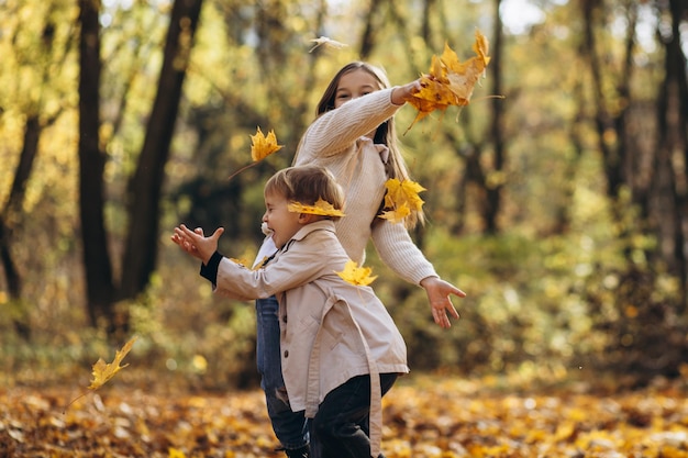 Brother with sister together in autumn park