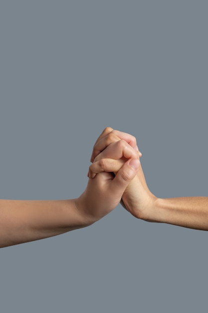 Brotherhood. Close-up of fair-skinned and dark-skinned hands clenched together