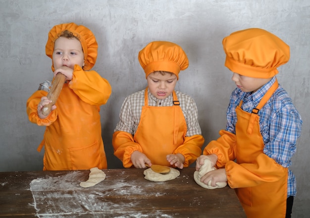 brothers help mom to cook pizza with sausage and cheese