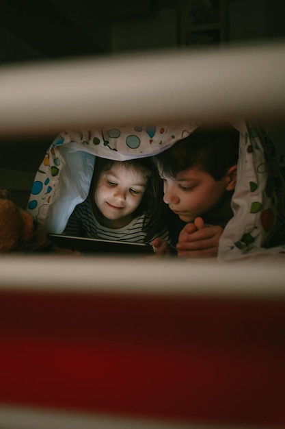 Brothers looking at the tablet in the dark