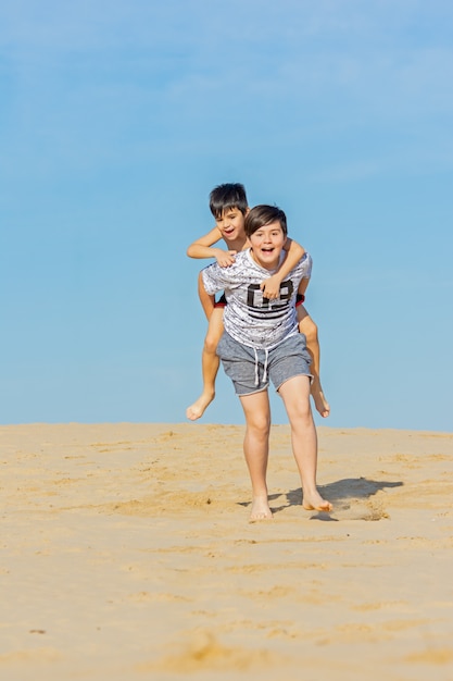 Foto fratelli che giocano tra le dune