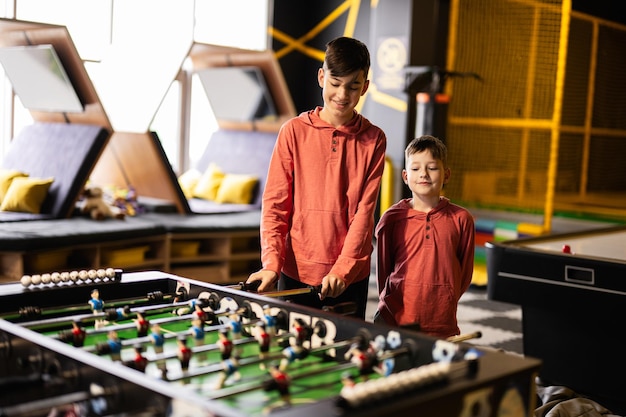 Brothers playing table football in kids play center