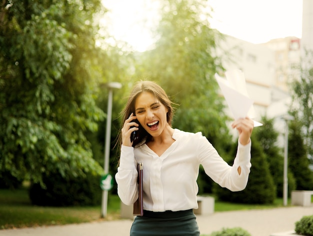 Brought to hysteria, angry business woman dressed in a white blouse and a skirt