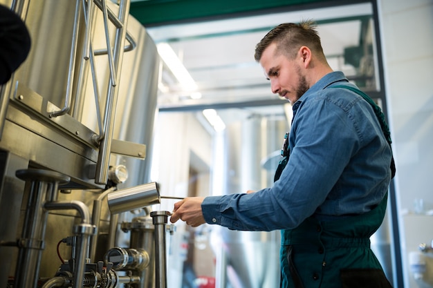 Brouwer die bier controleert bij brouwerij