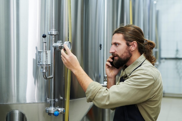 Brouwerijarbeider die barometer controleert