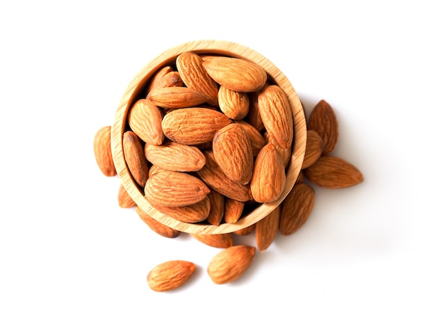 Brown Almond Seeds with wooden bowl isolated on white background.