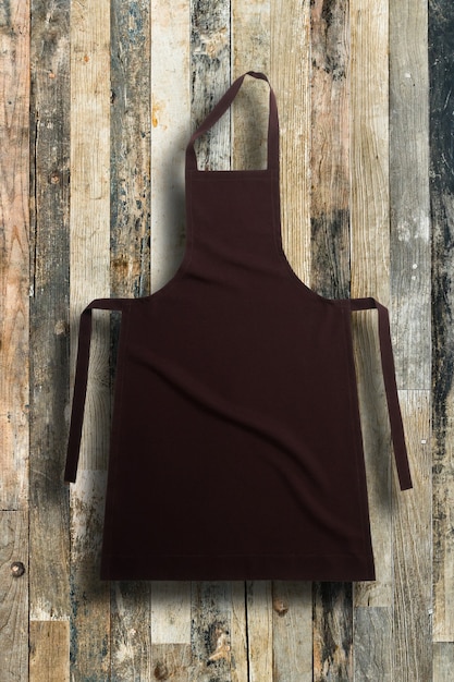 Brown apron against vintage wooden background or texture