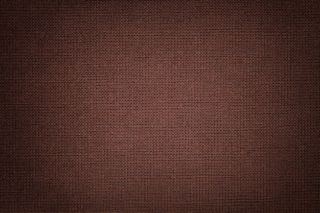 Brown background from a textile material with wicker pattern, closeup.