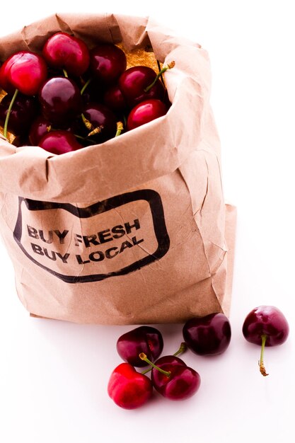 Brown bag of fresh cherries from the local farmers market.