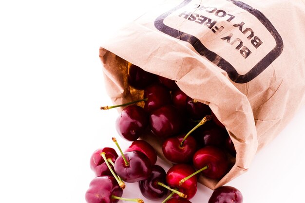 Brown bag of fresh cherries from the local farmers market.