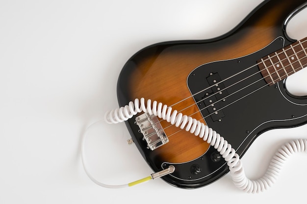 Brown bass guitar with white cable