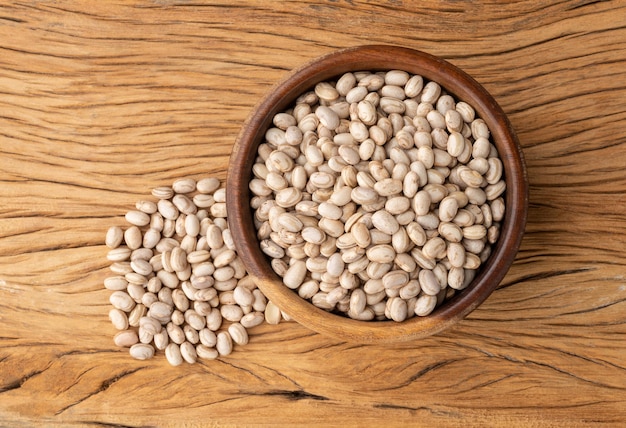 Brown beans on a bowl over wooden table