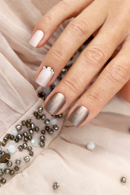 Brown beige manicure with rhinestones on short nails.