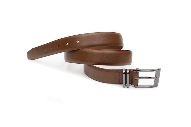 A brown belt with a metal buckle rolled up Selective focus Isolated on white background