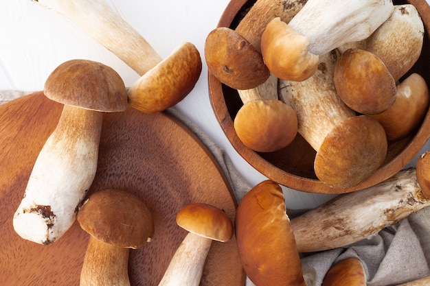 Brown boletus mushrooms on the background of a wooden tray. Top view.