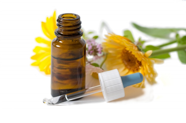 Brown bottle with calendula and chamomile flowers