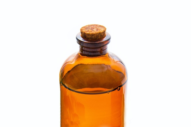 Brown bottle with essential oil on white surface