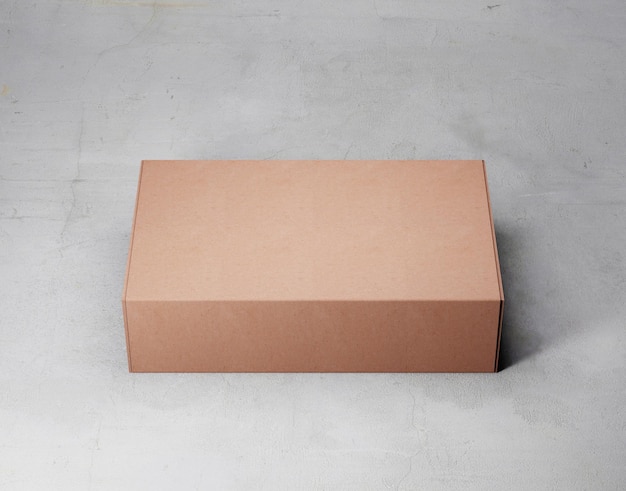 A brown box is on a gray surface with the word " on it " on the top.