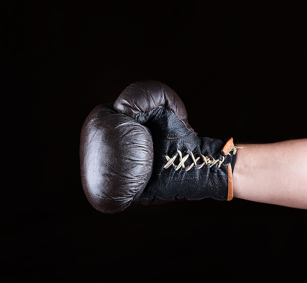 Brown boxing glove dressed on man's hand