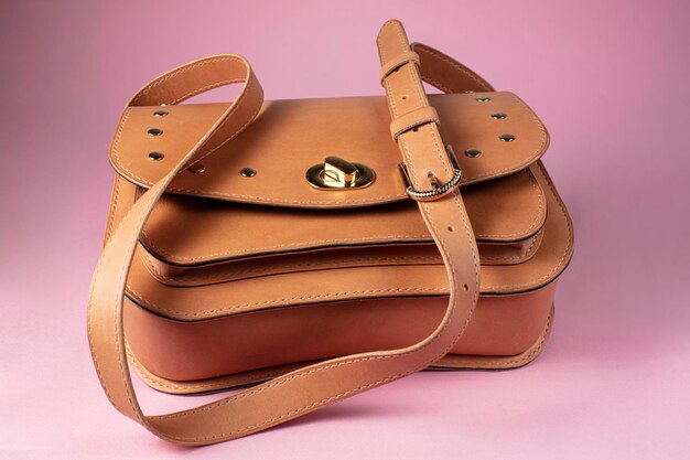 写真 ピンクの背景に真皮で作られた茶色のブリーフケースバッグ