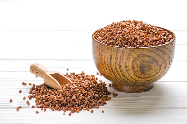 Brown buckwheat grains in wooden bowl