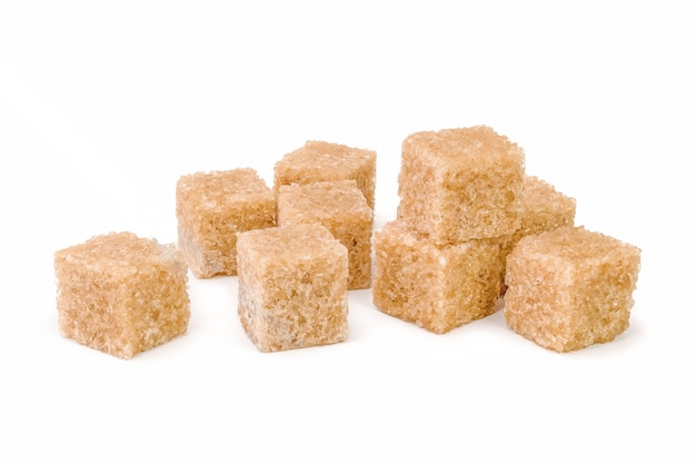 Кубики коричневого тростникового сахара, изолированные на белом вырезе