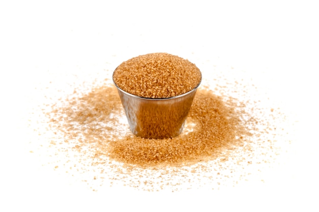 Brown cane sugar in metal bowl isolated on white background.