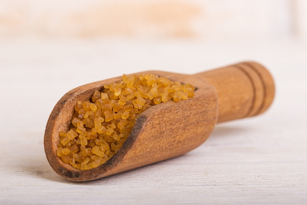 Brown cane sugar sand in a wooden spoon