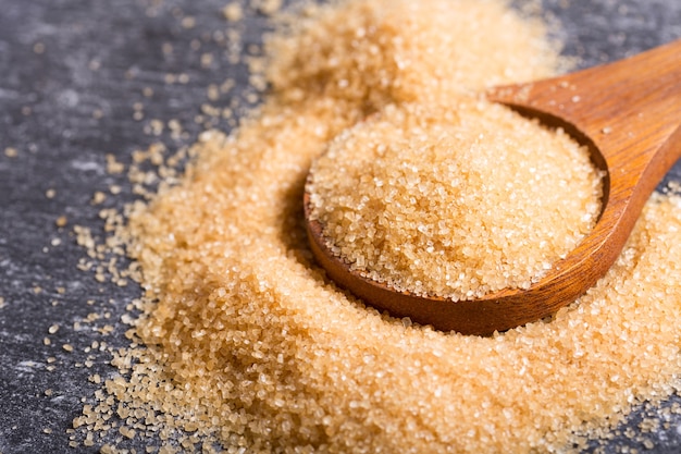 Brown cane sugar in a wooden spoon