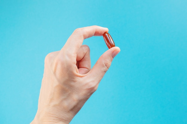 Brown capsule of lecithin in a female hand. The concept of vitamins, dietary supplements.