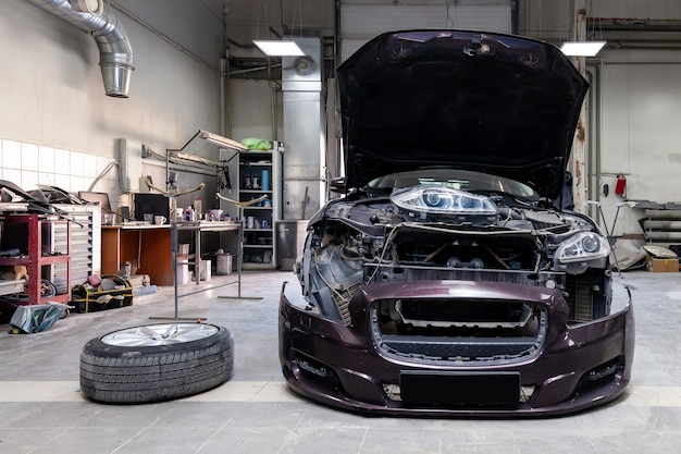 The brown car in the body of the sedan is preparing for painting the body without headlights and bumper in a workshop for repair vehicles Auto service industry
