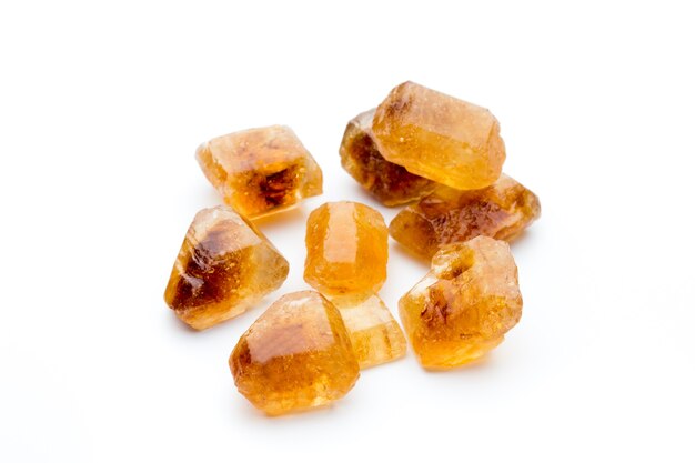 Brown caramelized lump cane sugar, isolated on white.