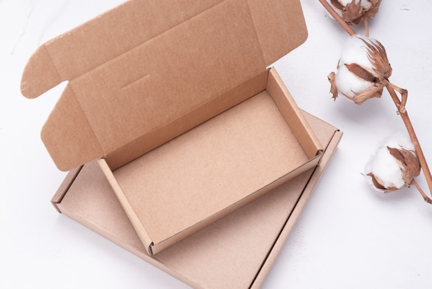 Photo brown cardboard box decorated with cotton flower branch