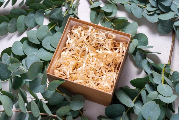 Brown cardboard carton box with filler decorated with Eucalyptus green branch